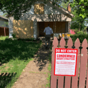 condemned sign on the fence in front of a property