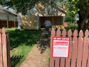 condemned sign on the fence in front of a property