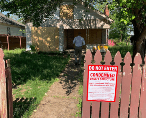 condemned sign on the fence in front of a property