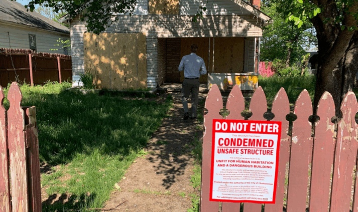 condemned sign on the fence in front of a property