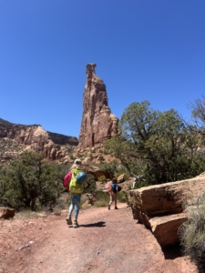 you see the backs of two kids hiking on Monument Trail with Independence Monument in the distance